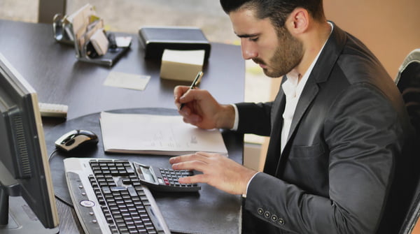 Man in formal wear working as accountant at desktop