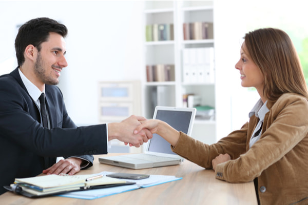 Woman giving handshake to financial adviser