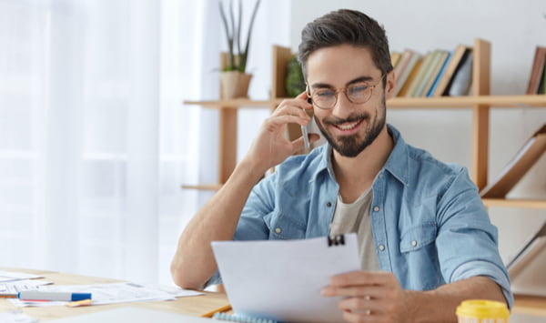 Happy young unexperienced male prepares business report
